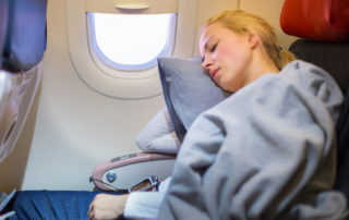 blonde woman sleeping on a plane